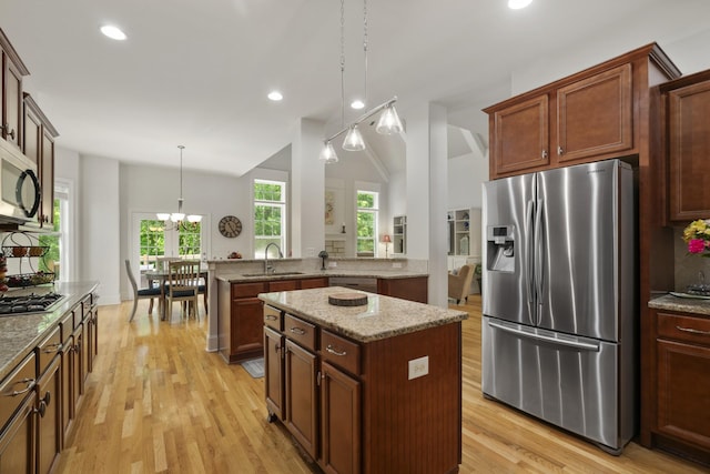 4019 Fremantle Cir, Spring Hill, TN 37174 - kitchen with stainless steel appliances, a sink, a kitchen island, lofted ceiling, and light wood-style flooring
