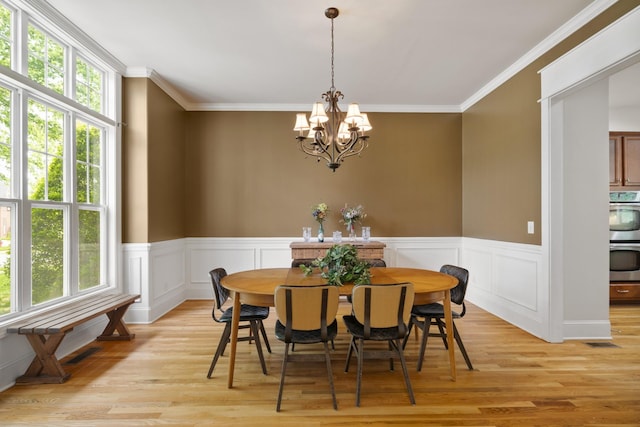 4019 Fremantle Cir, Spring Hill, TN 37174 - dining space featuring healthy amount of natural light, a chandelier, light wood-style floors, ornamental molding, and a wainscoted wall