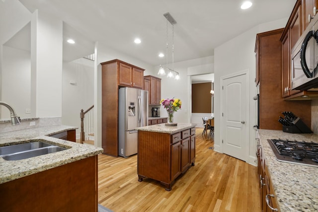 4019 Fremantle Cir, Spring Hill, TN 37174 - kitchen featuring appliances with stainless steel finishes, a sink, light wood finished floors, hanging light fixtures, and recessed lighting