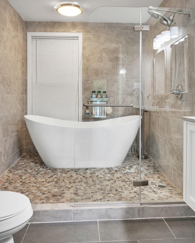 106 Lakewood Dr, Dickson, TN 37055 - full bath featuring tile walls, tile patterned flooring, a stall shower, a freestanding tub, and toilet