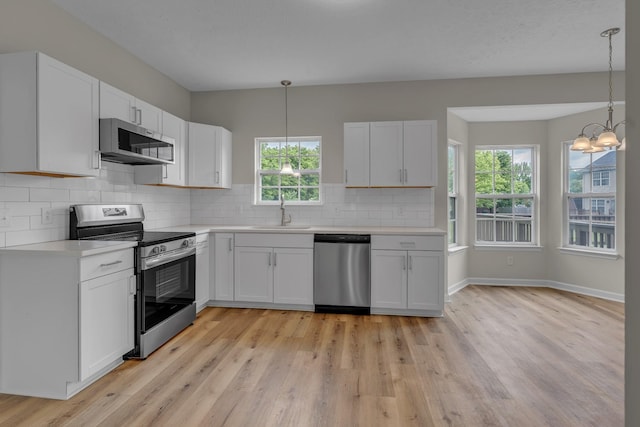 408 Jordan Leigh Ct, Joelton, TN 37080 - kitchen featuring appliances with stainless steel finishes, a sink, light countertops, light wood-style flooring, and a chandelier
