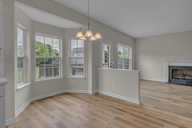 408 Jordan Leigh Ct, Joelton, TN 37080 - unfurnished dining area featuring light wood-style floors, a chandelier, baseboards, and a fireplace with flush hearth