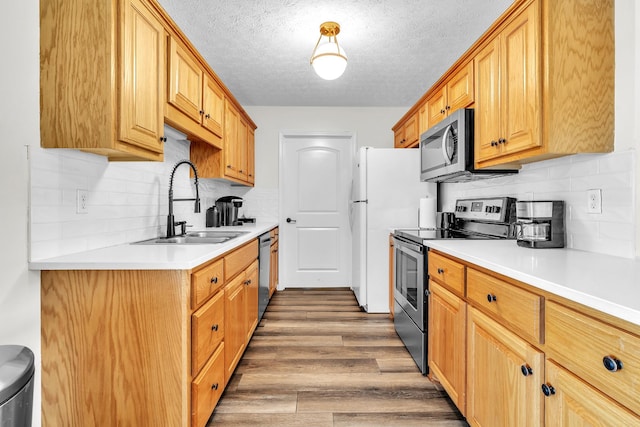 5440 Eugene Kennedy Ln, Cedar Hill, TN 37032 - kitchen featuring appliances with stainless steel finishes, a sink, a textured ceiling, tasteful backsplash, and light countertops