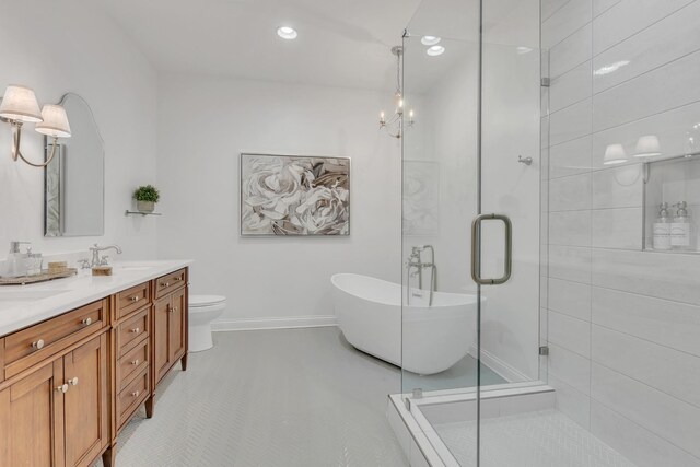 308 Stanley Park Ln, Franklin, TN 37069 - bathroom with a stall shower, double vanity, a freestanding bath, baseboards, and recessed lighting