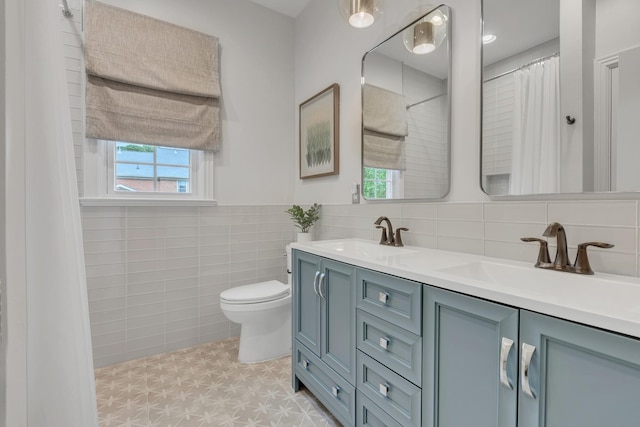 308 Stanley Park Ln, Franklin, TN 37069 - bathroom featuring tile walls, toilet, double vanity, tile patterned floors, and a wainscoted wall