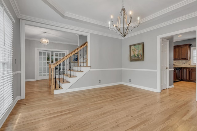 308 Stanley Park Ln, Franklin, TN 37069 - spare room with a chandelier, light wood-type flooring, stairs, baseboards, and crown molding