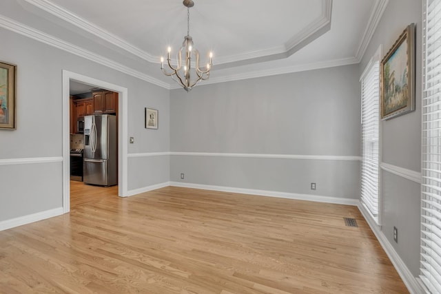 308 Stanley Park Ln, Franklin, TN 37069 - empty room with a chandelier, light wood-type flooring, healthy amount of natural light, a raised ceiling, and crown molding
