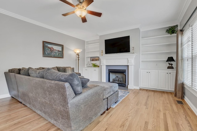 308 Stanley Park Ln, Franklin, TN 37069 - living area with a ceiling fan, built in shelves, healthy amount of natural light, ornamental molding, and a fireplace with flush hearth