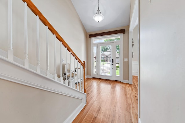 entryway with stairway, wood finished floors, and baseboards