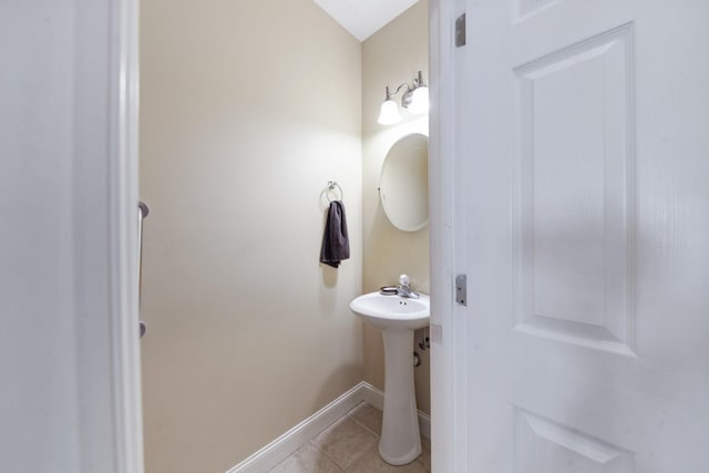 bathroom featuring tile patterned flooring, baseboards, and a sink
