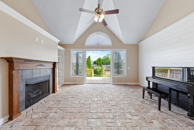 living area with a fireplace, ceiling fan, brick floors, baseboards, and wooden walls