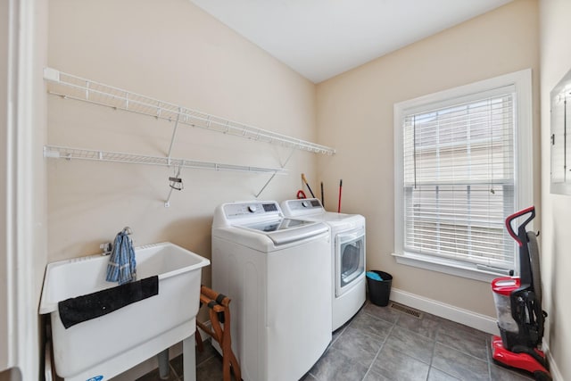 washroom featuring washer and dryer, healthy amount of natural light, and baseboards