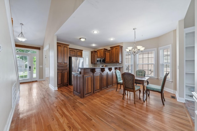 kitchen with appliances with stainless steel finishes, baseboards, a chandelier, light wood-style floors, and recessed lighting