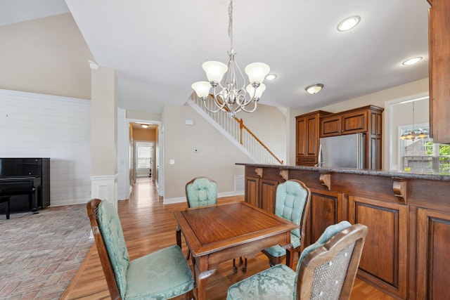 dining space featuring a chandelier, plenty of natural light, stairs, and baseboards