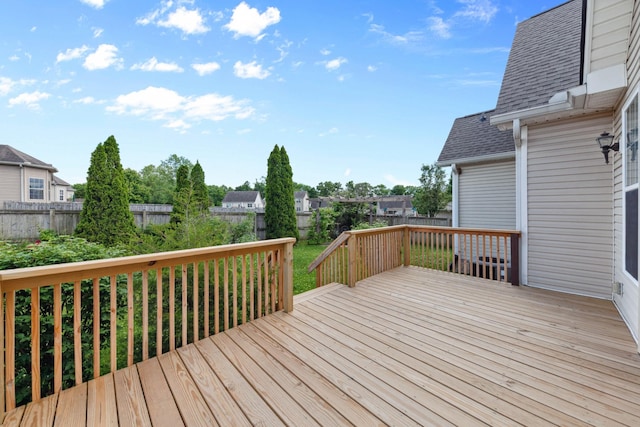 wooden terrace featuring a fenced backyard and a residential view