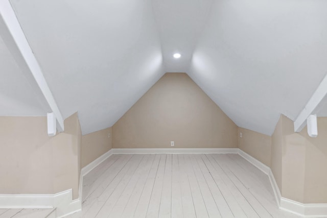 additional living space with light wood-type flooring, vaulted ceiling, baseboards, and recessed lighting