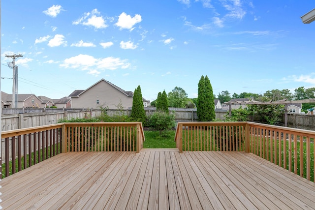 wooden terrace with a residential view and a fenced backyard