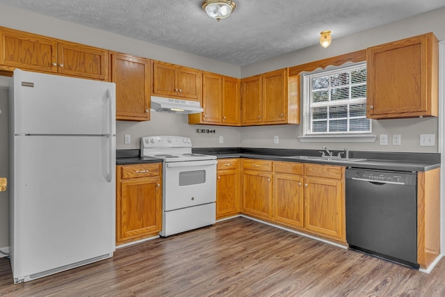 1514 Center Pointe Dr, Murfreesboro, TN 37130 - kitchen featuring white appliances, under cabinet range hood, a sink, dark countertops, and a textured ceiling
