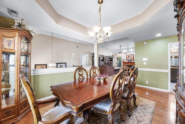845 Nandina Ct, Clarksville, TN 37043 - dining room with a chandelier, wood finished floors, ceiling fan, baseboards, and a tray ceiling