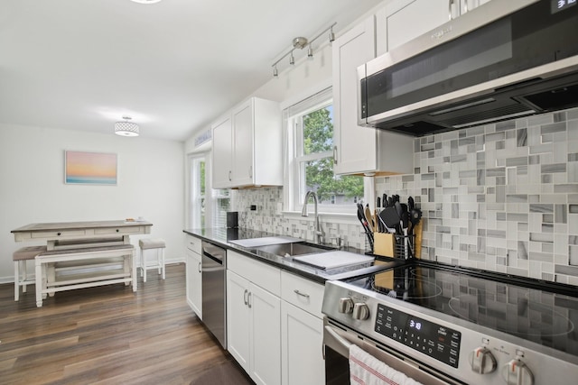 976 Long Beech Dr, Clarksville, TN 37042 - kitchen with stainless steel appliances, a sink, backsplash, dark countertops, and white cabinets