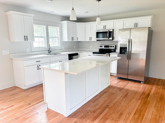 400 Circle Dr, Estill Springs, TN 37330 - kitchen featuring stainless steel appliances, a sink, white cabinets, light countertops, and a center island