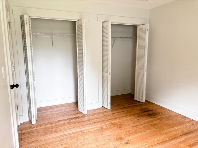 400 Circle Dr, Estill Springs, TN 37330 - unfurnished bedroom with multiple closets, light wood finished floors, and baseboards