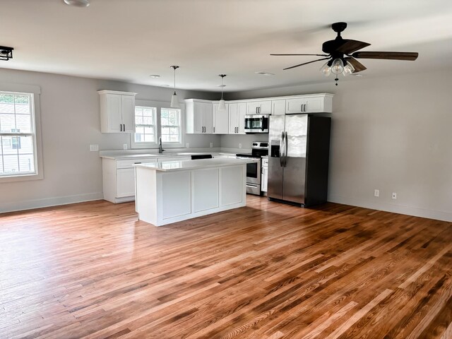 400 Circle Dr, Estill Springs, TN 37330 - kitchen with stainless steel appliances, light wood-type flooring, light countertops, a center island, and white cabinets