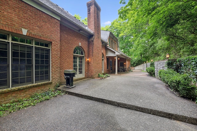 1130 Crater Hill Dr, Nashville, TN 37215 - view of side of property featuring brick siding, a chimney, french doors, and a patio area