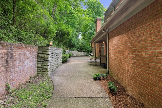1130 Crater Hill Dr, Nashville, TN 37215 - view of side of property featuring a chimney, a patio area, brick siding, and fence