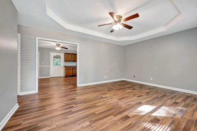 2290 Petway Rd, Ashland City, TN 37015 - empty room with a tray ceiling, a ceiling fan, dark wood-style flooring, and baseboards