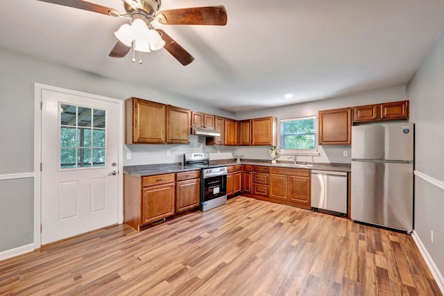 2290 Petway Rd, Ashland City, TN 37015 - kitchen featuring appliances with stainless steel finishes, under cabinet range hood, brown cabinets, and light wood-style flooring