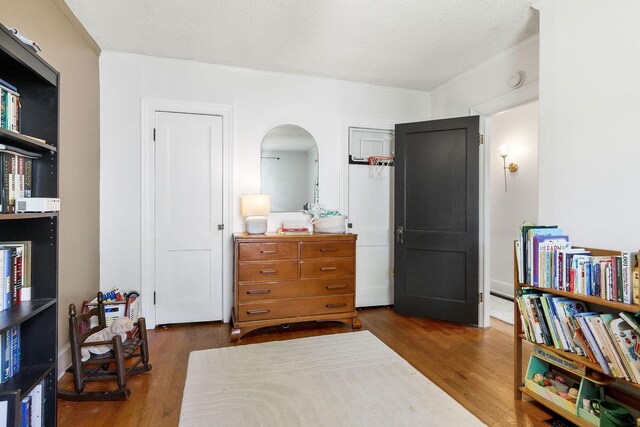 36 Hillcrest Dr, Sparta, TN 38583 - bedroom featuring ornamental molding, arched walkways, wood finished floors, two closets, and a textured ceiling