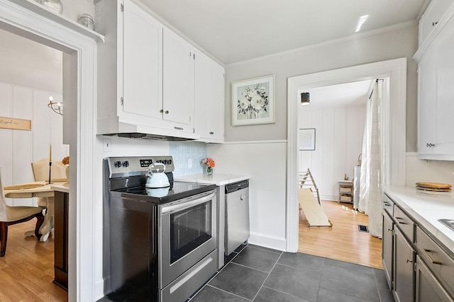 36 Hillcrest Dr, Sparta, TN 38583 - kitchen with stainless steel appliances, under cabinet range hood, light countertops, dark tile patterned flooring, and white cabinetry