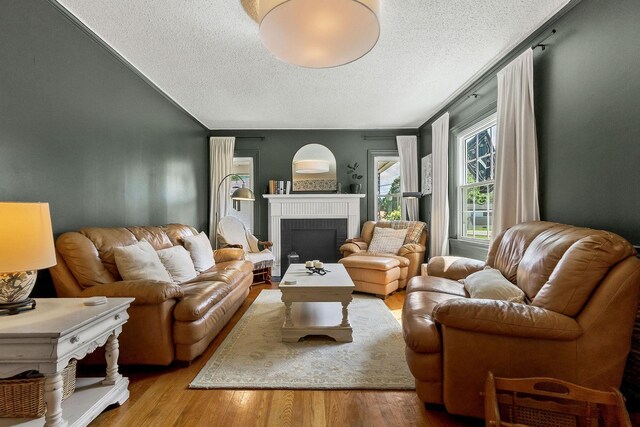 36 Hillcrest Dr, Sparta, TN 38583 - living room with a textured ceiling, a brick fireplace, wood finished floors, and vaulted ceiling