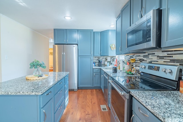 1689 Pleasant Ridge Rd, Huntland, TN 37345 - kitchen with stainless steel appliances, a sink, blue cabinetry, light wood-style flooring, and recessed lighting