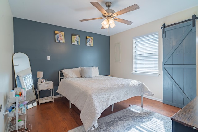 1689 Pleasant Ridge Rd, Huntland, TN 37345 - bedroom featuring a barn door, wood finished floors, baseboards, and a ceiling fan