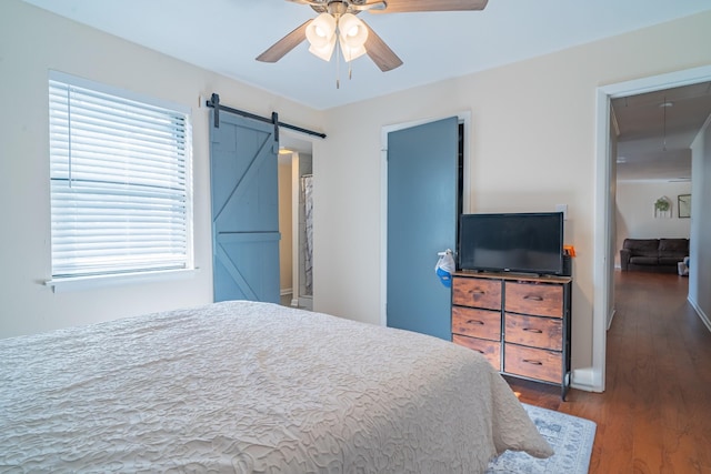 1689 Pleasant Ridge Rd, Huntland, TN 37345 - bedroom with a barn door, wood finished floors, ceiling fan, and baseboards