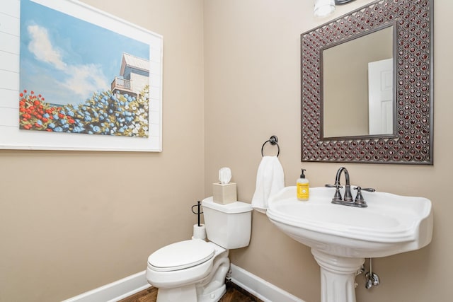 1002 Bradby Dr, Burns, TN 37029 - half bathroom with baseboards, toilet, wood finished floors, and a sink