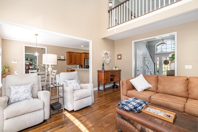 1002 Bradby Dr, Burns, TN 37029 - living area with dark wood-type flooring, stairs, a high ceiling, and baseboards
