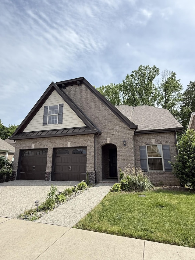 107 Auxley Ct, White House, TN 37188 - view of front facade with driveway, brick siding, a front lawn, an attached garage, and a standing seam roof
