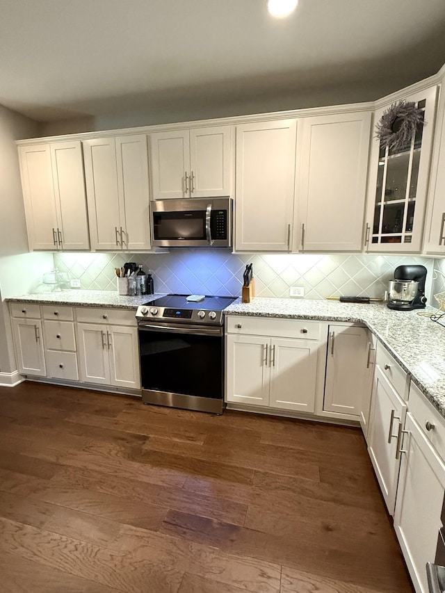 107 Auxley Ct, White House, TN 37188 - kitchen featuring stainless steel appliances, white cabinets, decorative backsplash, glass insert cabinets, and dark wood-style flooring