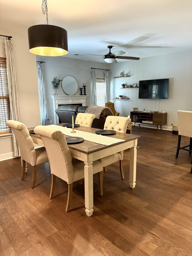 107 Auxley Ct, White House, TN 37188 - dining area with a fireplace, dark wood finished floors, a ceiling fan, and baseboards