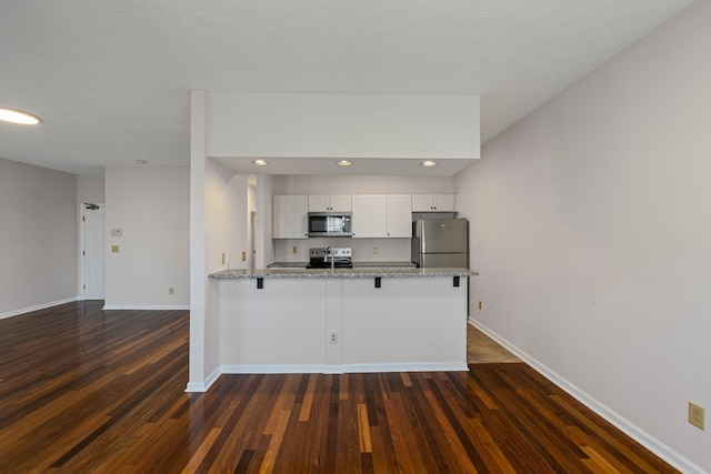 612 Churchill Xing, Madison, TN 37115 - kitchen with appliances with stainless steel finishes, baseboards, white cabinetry, dark wood-type flooring, and a peninsula
