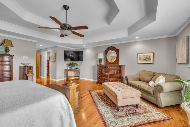 bedroom featuring a tray ceiling, crown molding, light wood finished floors, recessed lighting, and baseboards