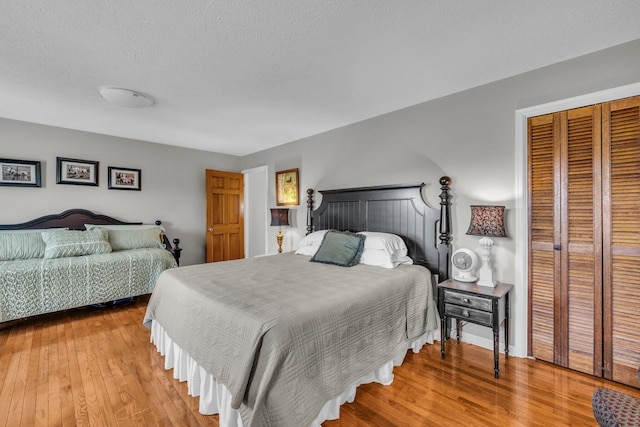 bedroom with hardwood / wood-style flooring, a closet, and a textured ceiling