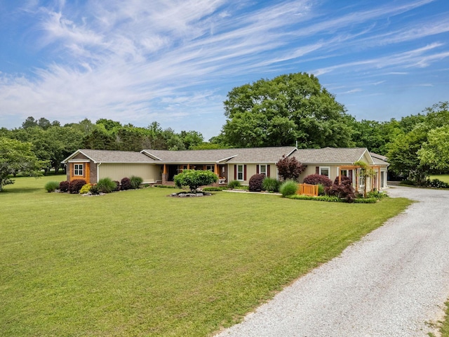 ranch-style house with gravel driveway and a front lawn