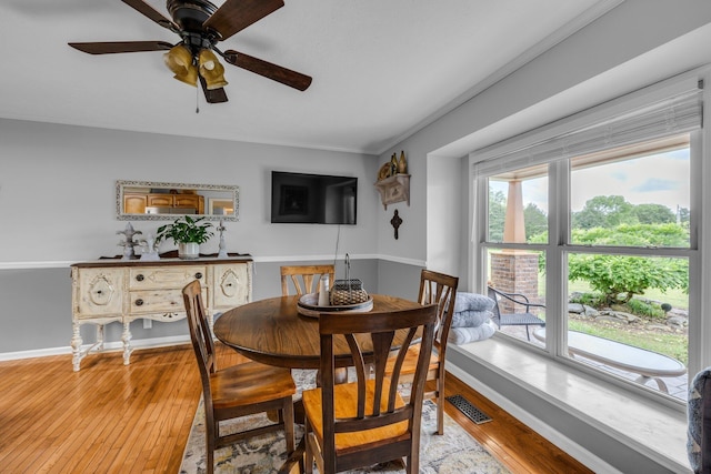 dining room with light wood-style floors, a ceiling fan, ornamental molding, and baseboards