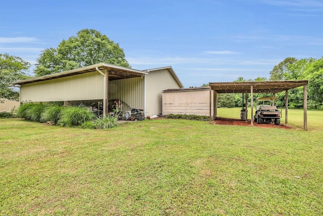 view of grassy yard featuring a carport and a pole building