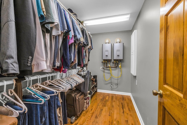 spacious closet with water heater and wood finished floors