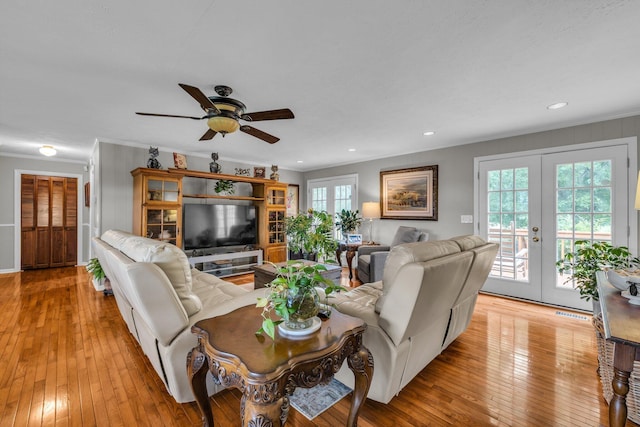 living room with french doors, ceiling fan, light wood-type flooring, ornamental molding, and recessed lighting